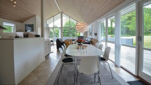 Una cocina moderna con comedor, ventanas amplias y vistas al exterior.
