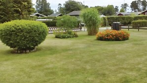 A well-maintained lawn with a variety of shrubs and a flower bed. - 2 bedroom awesome home in Sölvesborg (Sölvesborg)