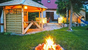 A wooden gazebo with a fire pit in the center, surrounded by a stone pathway and a grassy area. - Beautiful home in Wicko with WiFi (Wicko)