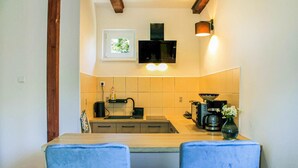 A compact kitchen with a microwave, toaster, and coffee maker. There is a window with a view of greenery, and a vase with flowers on the counter. - Beautiful home in Wicko with WiFi (Wicko)