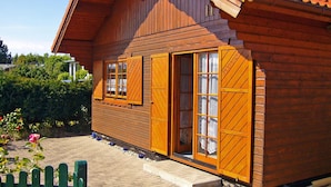 Une maison en bois avec de grandes fenêtres et une véranda.