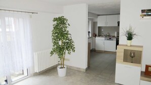 A modern apartment with a potted plant, a kitchen, and a dining area. - Apartment Starfish - Apartment starfish (Graal-Müritz)