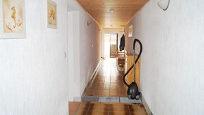 A hallway with wooden ceiling, tiled floor, and artwork on the walls. - Apartment Starfish - Apartment starfish (Graal-Müritz)