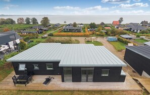 Une maison moderne avec un toit plat, de grandes fenêtres et une terrasse.