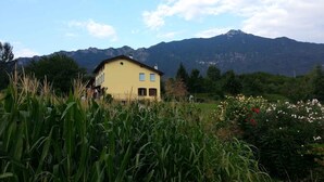 A yellow house with a mountain backdrop. - Holiday home with garden and mountain view (Velo d Astico)
