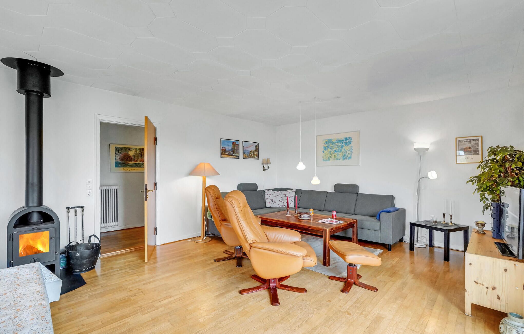 Un salon comprenant un canapé, deux fauteuils, une table basse et une cheminée.