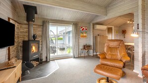 A cozy living room with a fireplace, leather armchair, and a television. - 3 bedroom amazing home in Egernsund (Egernsund)