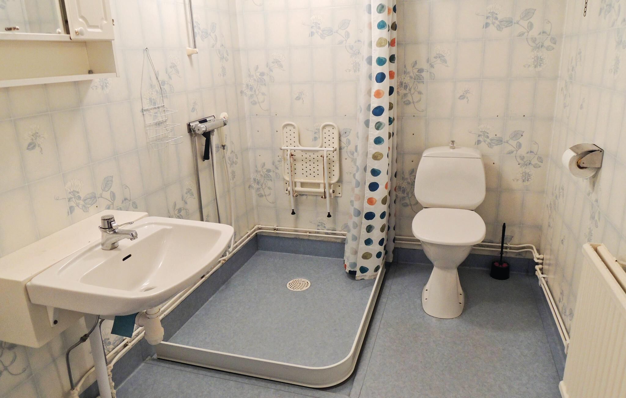 A bathroom with a shower, toilet, and sink.