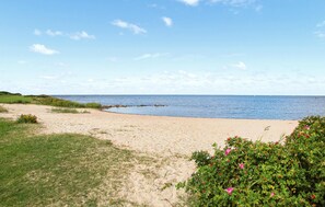 Escape to a serene beach setting with a wide sandy shore and calm sea.