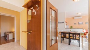 A modern interior with a wooden door, a dining area with a table and chairs, and a kitchen in the background. - Cozy home in Labin with kitchen (Labin)