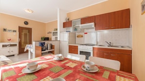 A compact kitchen with wooden cabinets, a gas stove, and a white refrigerator. - Cozy home in Labin with kitchen (Labin)