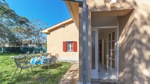 A house with a covered outdoor seating area, a door leading inside, and a visible window with shutters. - Cozy home in Labin with kitchen (Labin)