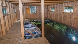 Une cabane en bois avec un petit quai et un étang.