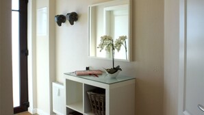 A hallway with a white console table, a mirror, and two wall-mounted decorative items. - (252) 2-room apartment - apartment complex holiday dreams (Kühlungsborn)