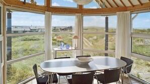 En matplats med ett bord och stolar, stora fönster och utsikt över landskapet.