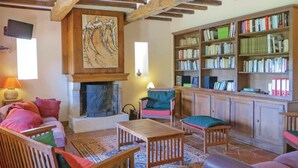 A cozy living room with a fireplace, a bookshelf, and comfortable seating.