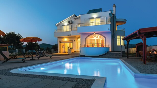 A two-story house with a swimming pool, outdoor seating, and a covered patio area. - Gorgeous home in Brodarica (Brodarica)