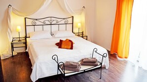A bed with a canopy, two bedside tables with lamps, and a set of towels on the floor. - Vacation apartment 03 with sea view - Strandhaus Göhren 100 m to the beach! (Göhren)