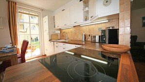 Una cucina moderna con isola centrale, pensili bianchi e un'ampia finestra.