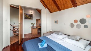 Ein Schlafzimmer mit einem Bett, einem Schreibtisch und einer Treppe.