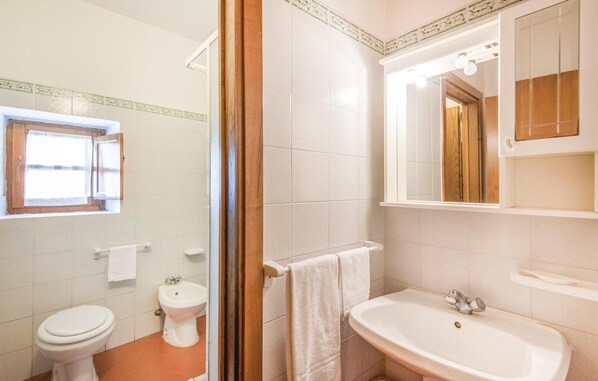 Un baño con inodoro, bidé y lavamanos.