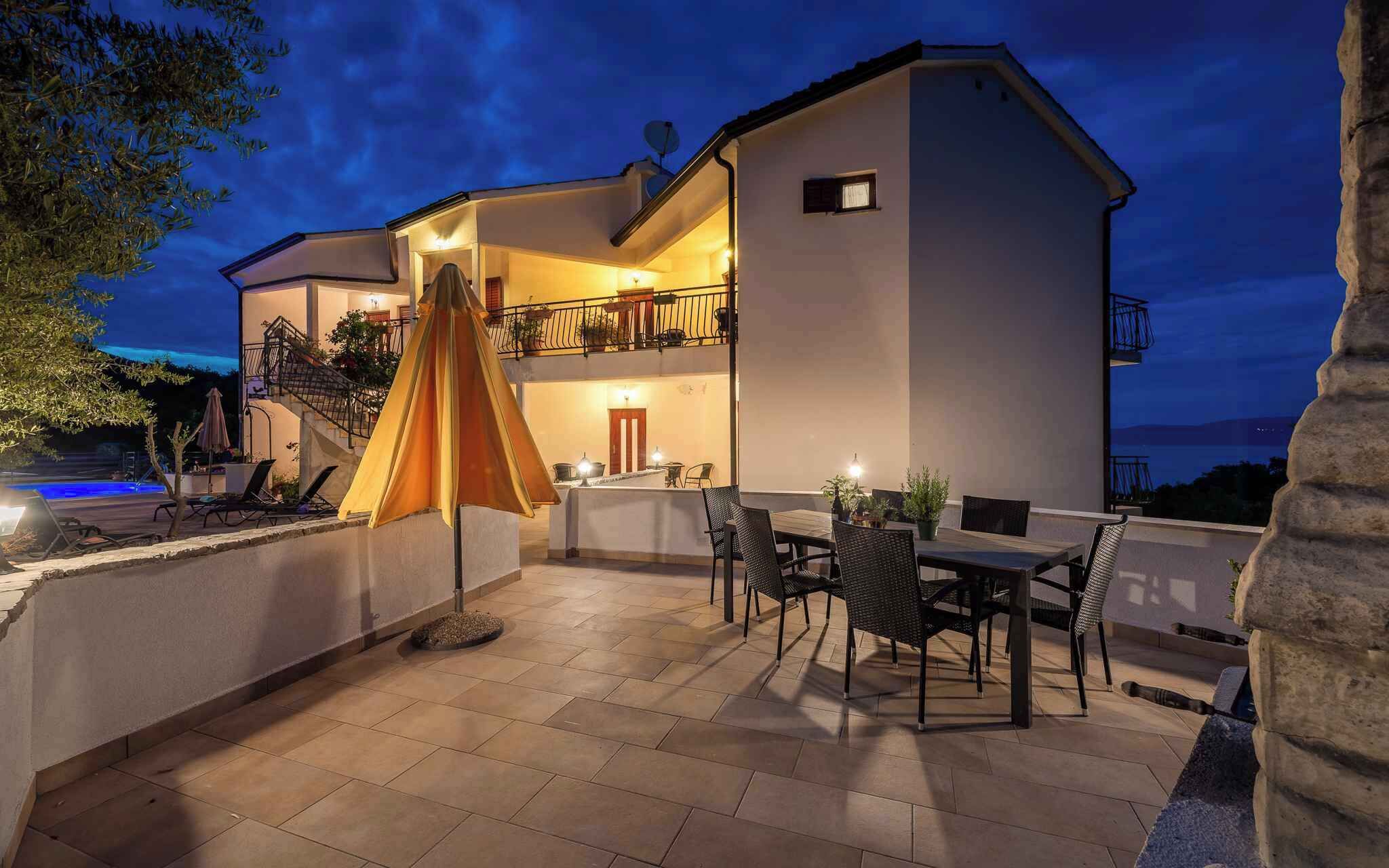 Een gebouw met twee verdiepingen, een terras, zitplaatsen buiten en een zwembad.