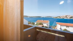Un balcon donnant sur une ville côtière et la mer.