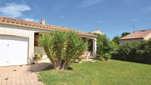 A house with a tiled roof, a garage door, and a well-maintained lawn.