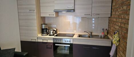 Een koelkast, een oven, een koffiezetapparaat/waterkoker, een waterkoker