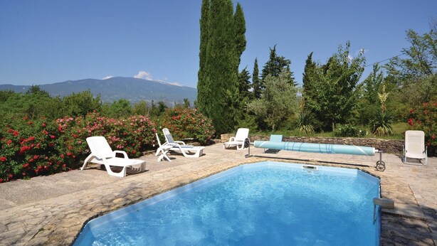 Ein Poolbereich mit Liegestühlen und Blick auf einen Berg.