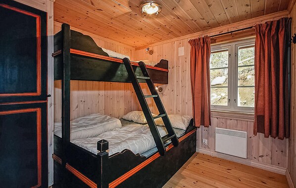 A bunk bed room with wooden walls and a window with curtains. - Nice home in Hemsedal with sauna (Hemsedal)