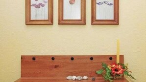 Een houten bank met een bloemenvaas en een kaars.