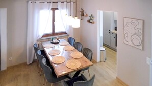 Un comedor con una mesa de madera, seis sillas y protectores de mesa tejidos.
