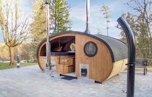 A wooden, barrel-shaped structure with a chimney, a small window, and a door. - Ferienhaus 15 in Kirchheim (Kirchheim)