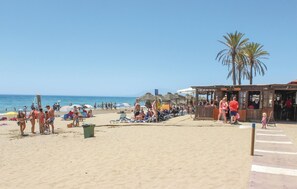 A beach with people, umbrellas, and a bar area. - Beach front home in Marbella (Marbella)