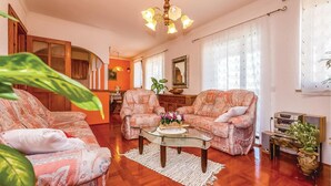 A living room with patterned sofas, a glass coffee table, and a chandelier. - Beautiful apartment in Crikvenica (Crikvenica)