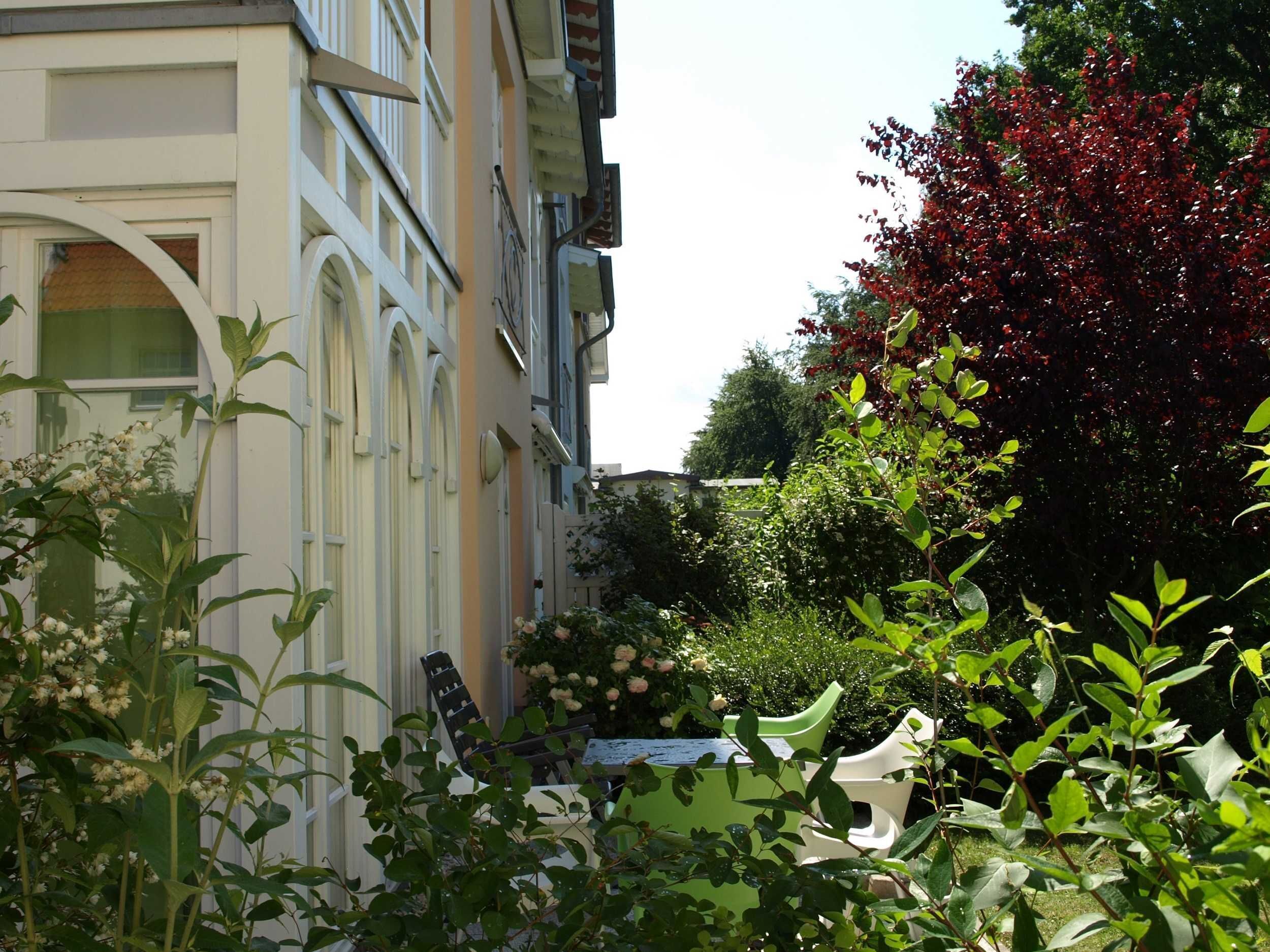 Un immeuble doté d’un balcon et d’un jardin où poussent différentes plantes et fleurs.