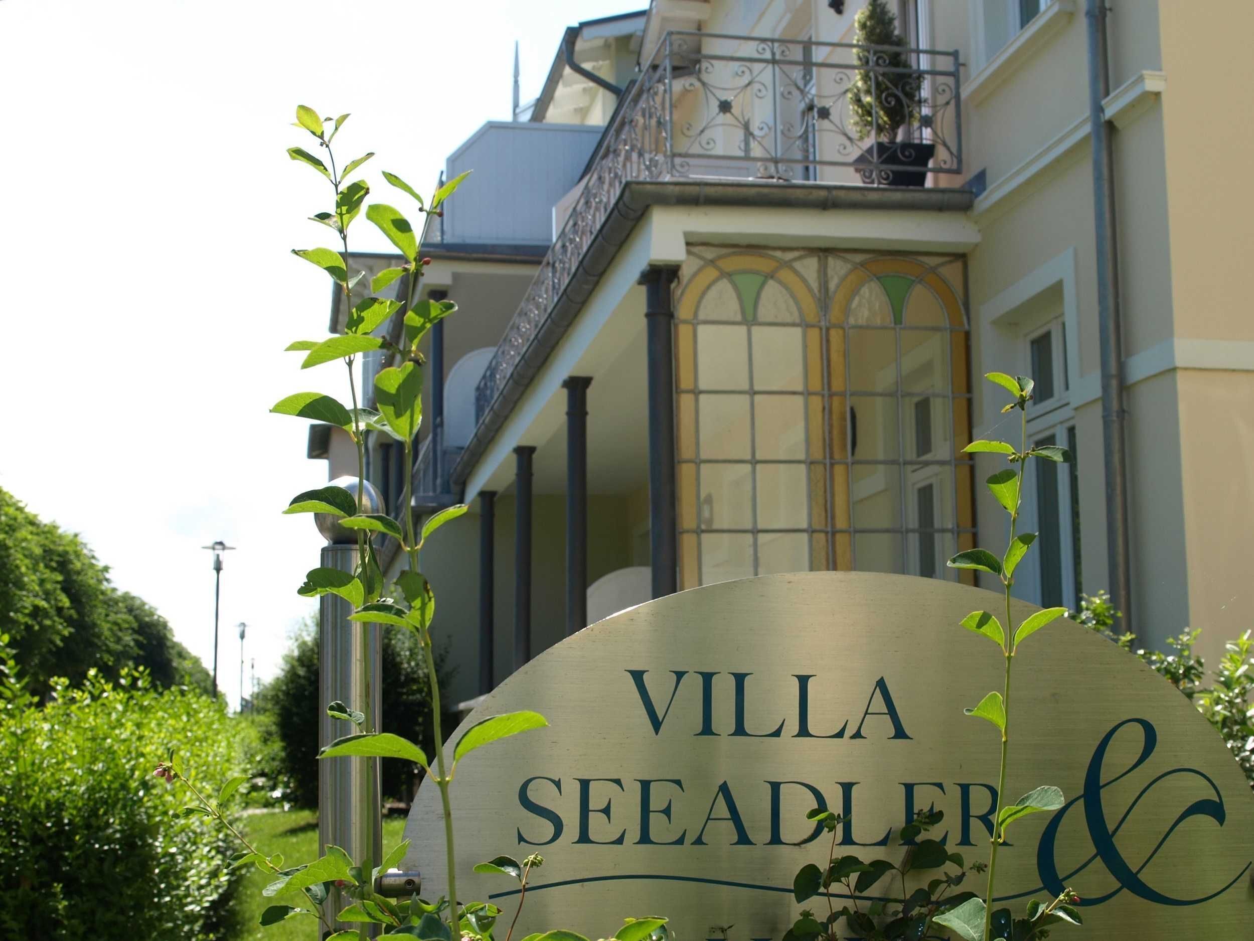 Letrero de Villa Seeadler & Co. con un estilo arquitectónico clásico, que incluye un balcón y ventanas amplias.