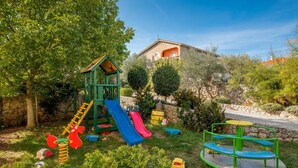 Un parque infantil con tobogán, estructura para escalar y columpios.