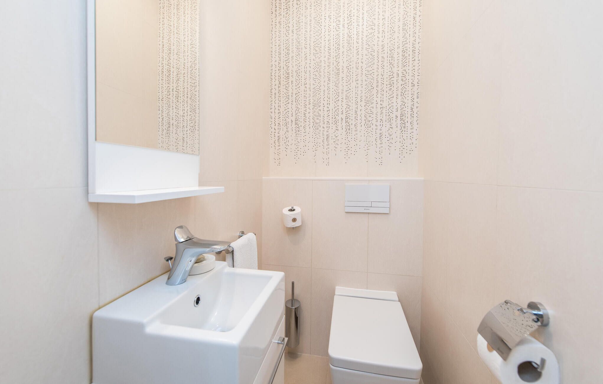 A bathroom with a sink, toilet, and a towel rack.