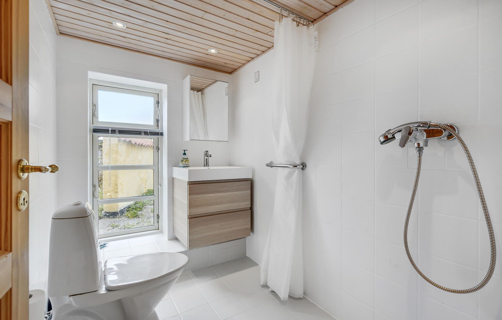 A bathroom with a toilet, sink, and shower.