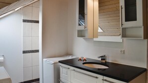 A modern bathroom with a black sink, white cabinets, and a wooden ceiling. - Cozy home in Ringkøbing with sauna (Ringkøbing)