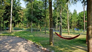 Un parque con un camino de grava, una hamaca y una cerca.