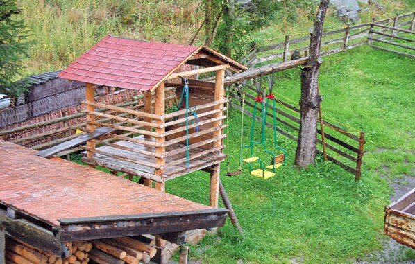 A rustic wooden structure with a red roof, a wooden platform, and a swing set. - Stunning home in Rinn b. Innsbruck (Rinn b. Innsbruck)