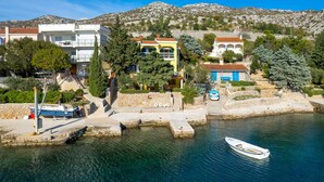 A coastal town with buildings, a marina, and a boat. - 1 bedroom beach front apartment in Lukovo Sugarje (Lukovo Sugarje)