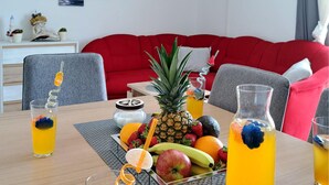 A dining table with a fruit bowl, drinks, and a pineapple centerpiece. - Beautiful home in Blizina Gornja (Blizina Gornja)
