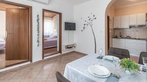 Ein kompakter Wohnraum mit Essbereich, Küchenzeile und Schlafzimmer mit Blick.