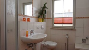 Un baño con lavamanos, inodoro y ventana.