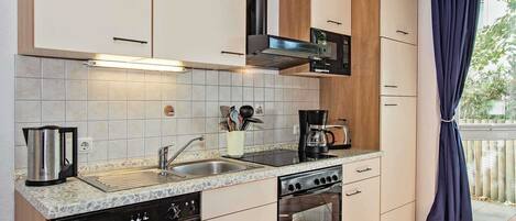 A modern kitchen with a dishwasher, stove, oven, and microwave.