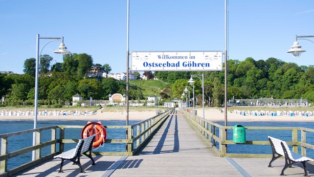A pier with benches and a sign welcoming visitors to Ostseebad Göhren.